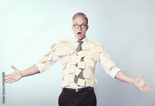 Photo: Shocked businessman covered by blank post-it notes. Shocked businessman covered by blank post-it notes.