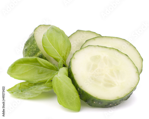 Photo: Sliced cucumber vegetable and basil leaves still life Sliced cucumber vegetable and basil leaves still life