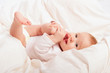 small baby sucking her finger on leg