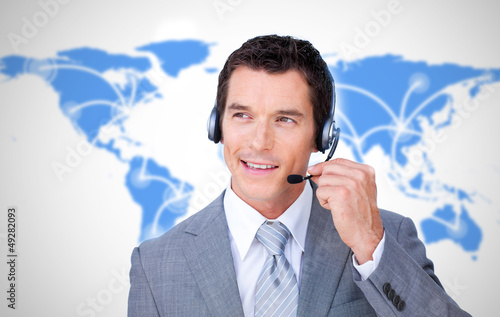 Photo: Smiling businessman using headset Smiling businessman using headset
