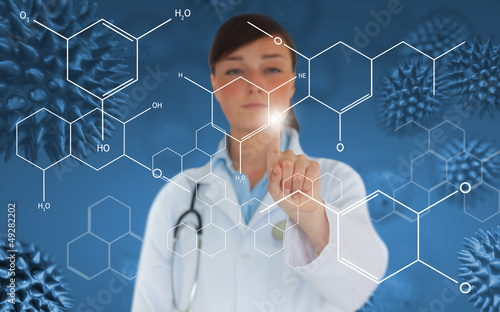Photo: Doctor pressing touchscreen displaying holographic chemical form Doctor pressing touchscreen displaying holographic chemical form