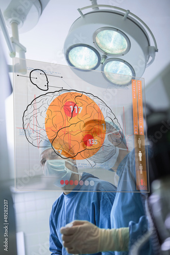 Photo: Two surgeons looking at the brain on an interface Two surgeons looking at the brain on an interface