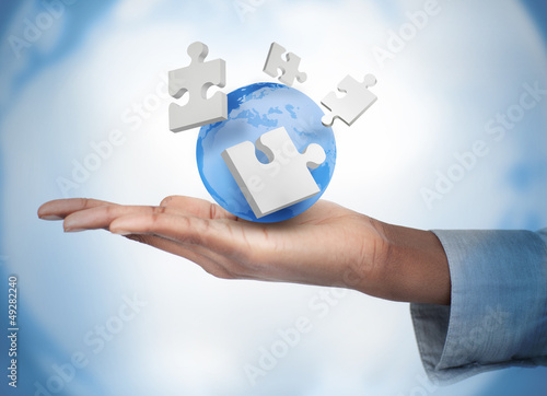 Photo: Hand with digital puzzles and a globe Hand with digital puzzles and a globe