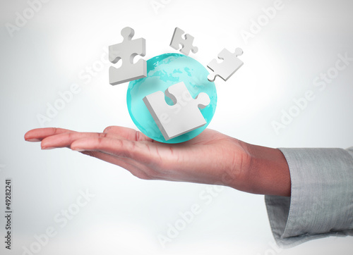 Photo: Hand with digital puzzles and a globe Hand with digital puzzles and a globe