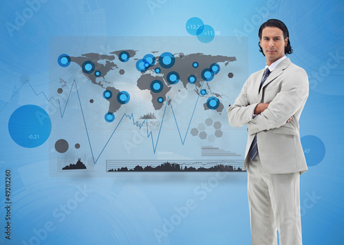 Photo: Serious businessman standing with a digital world map Serious businessman standing with a digital world map