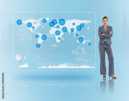 Photo: Businesswoman standing near to a futuristic screen Businesswoman standing near to a futuristic screen
