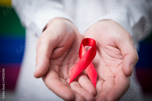 Photo: Man holding red aids ribbon Man holding red aids ribbon