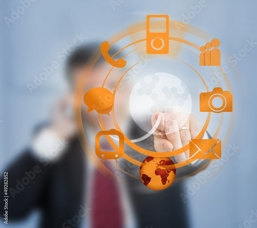 Photo: Businessman using orange wheel interface for computer applicatio Businessman using orange wheel interface for computer applicatio