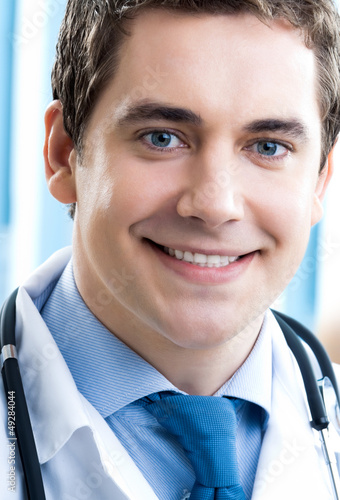 Photo: Happy smiling young doctor at office Happy smiling young doctor at office