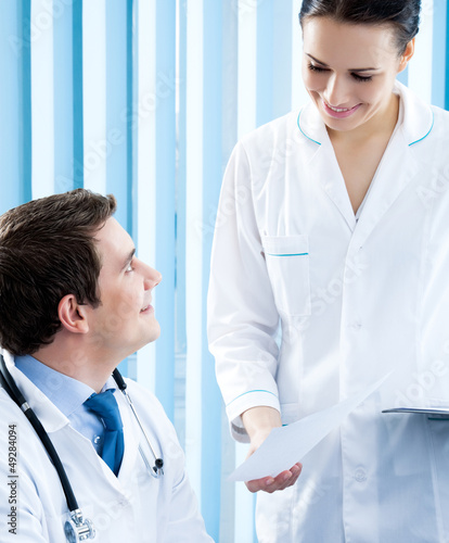 Photo: Two happy medical people working at office Two happy medical people working at office