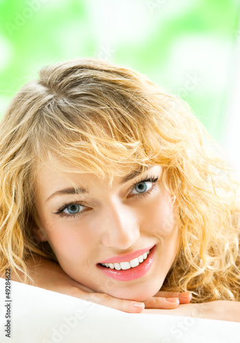 Photo: Young woman waking up on bed Young woman waking up on bed