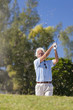 Happy Senior Man Playing Golf Ball Out of a Bunker