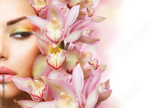 Photo: Beautiful Girl With Orchid Flowers. Beauty Model Woman Face Beautiful Girl With Orchid Flowers. Beauty Model Woman Face