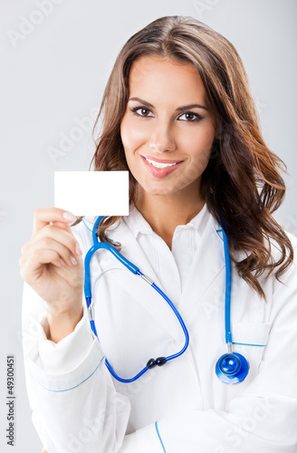 Photo: Young female doctor showing blank business card Young female doctor showing blank business card