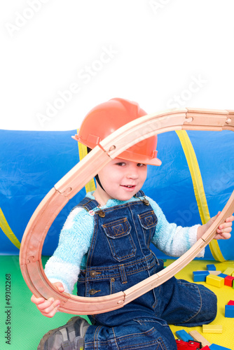 Photo: Kleiner Bauarbeiter spielt mit Schienen Kleiner Bauarbeiter spielt mit Schienen