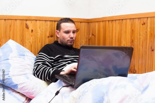 Photo: Man with laptop in bed Man with laptop in bed