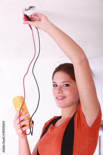 Photo: Female electrician fixing ceiling lighting Female electrician fixing ceiling lighting