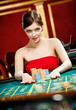 Photo: Playing roulette woman places a bet at the casino club Playing roulette woman places a bet at the casino club