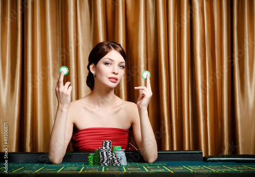 Photo: Woman with chips sitting at the casino table Woman with chips sitting at the casino table