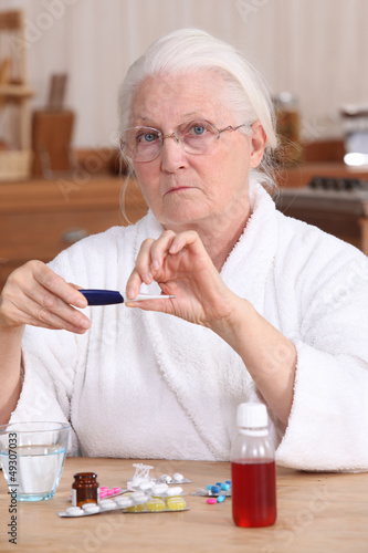 Photo: Elderly woman taking her medication Elderly woman taking her medication