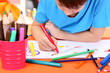 Cute little boy drawing in his notebook