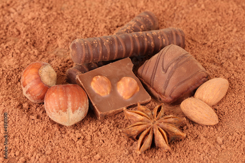 Photo: Chocolate sweets with cocoa, on brown background Chocolate sweets with cocoa, on brown background
