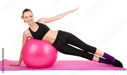 Photo: Young woman doing fitness exercises with gym ball isolated Young woman doing fitness exercises with gym ball isolated