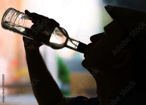 Photo: Silhouette of man drinking alcohol, close up Silhouette of man drinking alcohol, close up