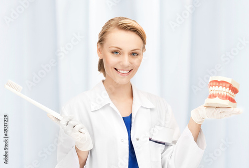 Photo: attractive female doctor with toothbrush and jaws attractive female doctor with toothbrush and jaws