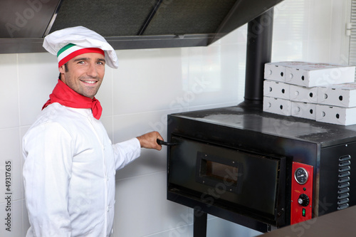 Photo: Pizzeria chef next to oven Pizzeria chef next to oven