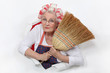 Granny with her hair in rollers holding a broom