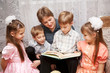 Happy mother and four children reading a book.
