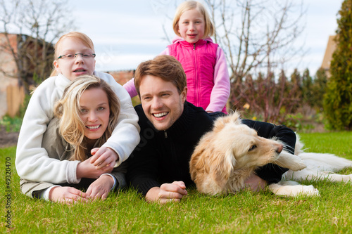 Photo: Eine Familie sitzt zusammen auf einer Wiese Eine Familie sitzt zusammen auf einer Wiese