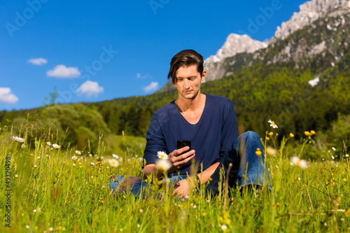 Photo: man with phone sitting in the mountains man with phone sitting in the mountains
