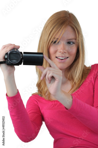 Photo: Woman holding compact video camera Woman holding compact video camera