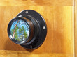 Old camera lens with green forest reflection.