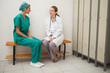 Doctor and a nurse sitting on a bench speaking