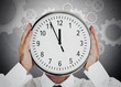 Businessman hiding his face with white clock