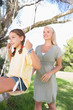 Foto: Happy mother pushing her daughter on a swing Happy mother pushing her daughter on a swing