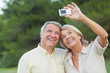 Older couple taking a photo of themselves and smiling