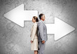 Business partners standing back to back on wall with arrows