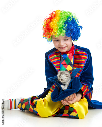 Photo: Boy clown with kitten inside hat over the white background Boy clown with kitten inside hat over the white background