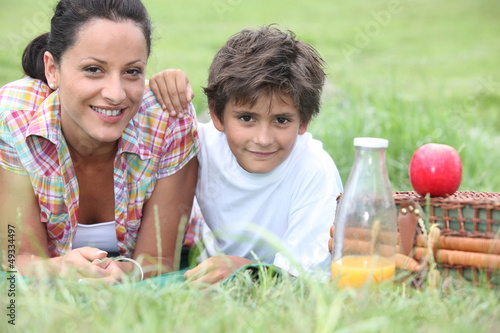 Photo: mother and son having picnic in the park mother and son having picnic in the park