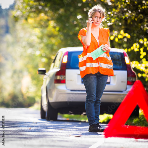 Photo: Young female driver calling the roadside service Young female driver calling the roadside service
