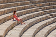 Photo: Girl is sitting on the steps of amphitheater Girl is sitting on the steps of amphitheater