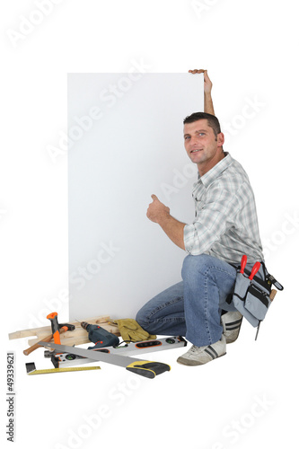 Photo: Carpenter posing by advertising panel Carpenter posing by advertising panel