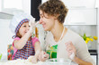 Young mother with little daughter preparing cookies