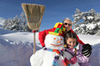 Little girl and granddad with their snowman