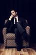 Man with cigarette sitting in vintage armchair
