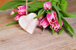 Holzherz und rose Tulpen auf einem alten Holt Brett